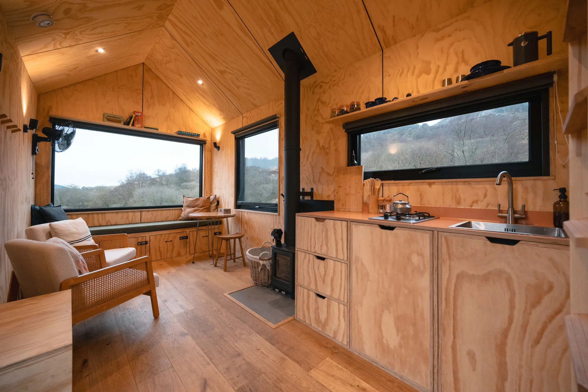 Inside the Leo cabin: full-length view down the timber interior with kitchen, seating and the mezzanine ladder