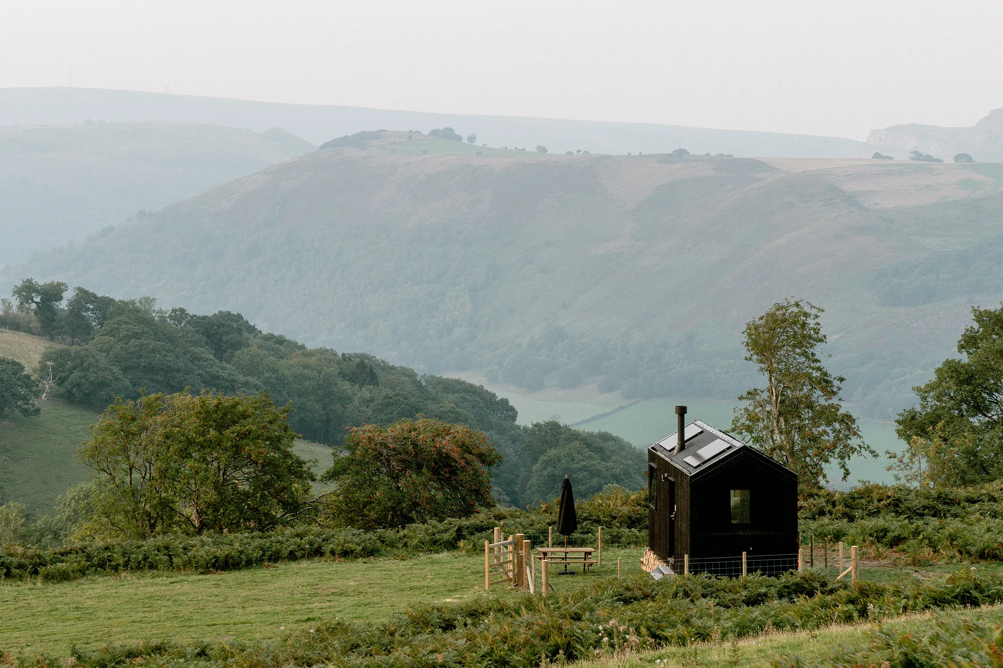 A black-timber Shacks cabin on a hilltop above the Llangollen valley