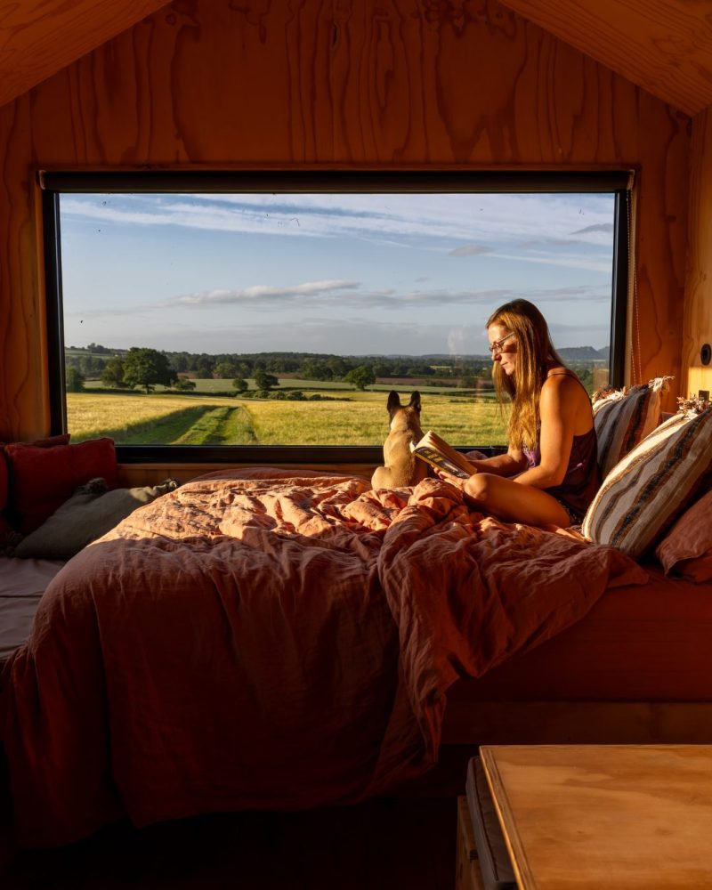 a solo traveller and her dog relaxing in an off-grid cabin.